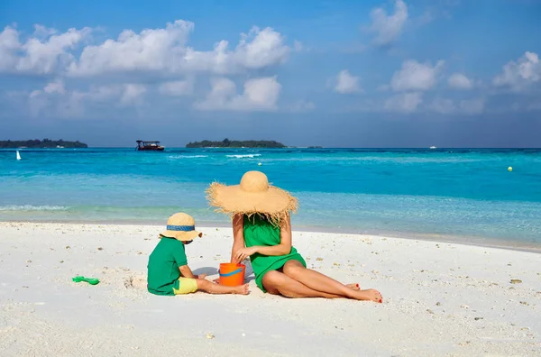 Femme en robe verte avec garçon de trois ans sur la plage — Photo