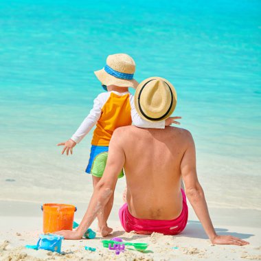 Babası ile sahilde yürümeye başlayan çocuk