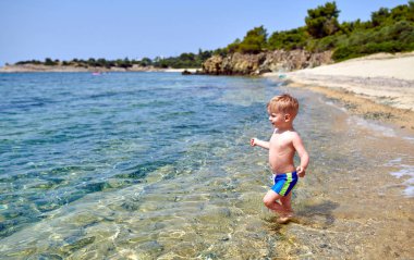 Sahilde yürümeye başlayan çocuk 