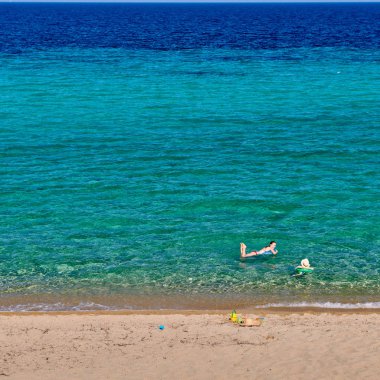 Yürümeye başlayan çocuk annesi ile sahilde 