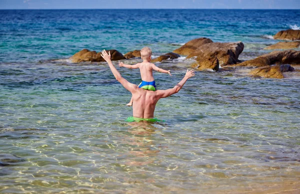 Plajda babasının omuzlarında yürümeye başlayan çocuk — Stok fotoğraf