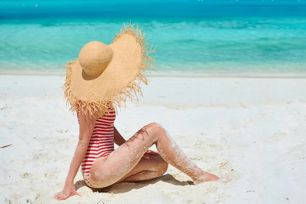 Kvinna i ett stycke baddräkt på stranden — Stockfoto