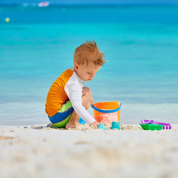 Three year old toddler playing on beach — Stock Photo, Image