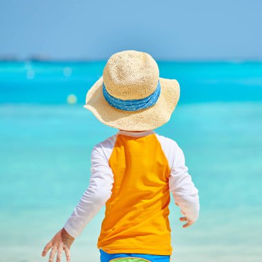 Plajda üç yaşında bir yürümeye başlayan çocuk