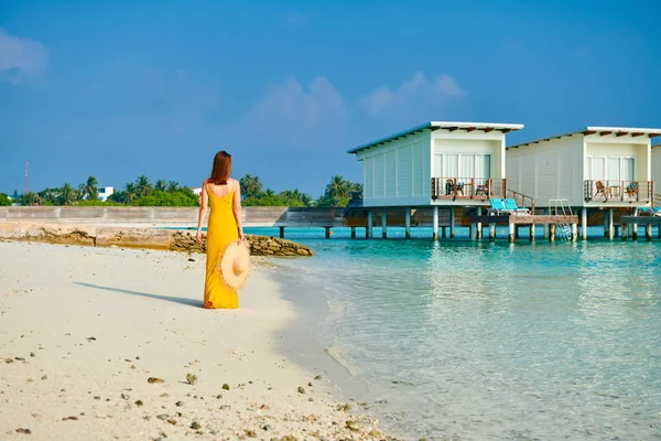 Frau in Kleid spaziert am tropischen Strand — Stockfoto