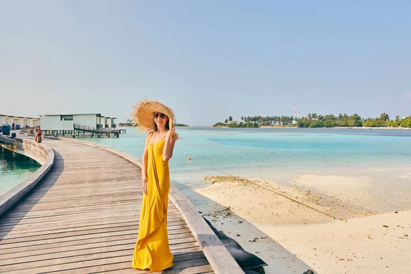 Mujer en vestido caminando en paseo marítimo de playa tropical — Foto de Stock