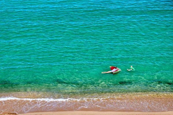 Pojken och hans mamma på stranden med uppblåsbar flottör — Stockfoto