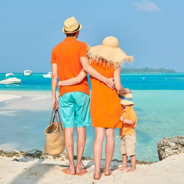 Üç palmiye ağacının altında sahilde aile