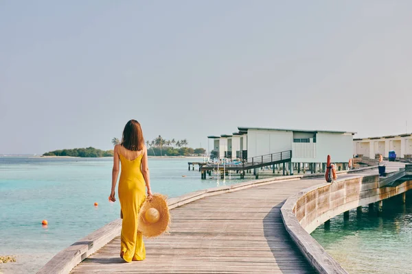 Mulher de vestido andando na praia tropical calçadão — Fotografia de Stock