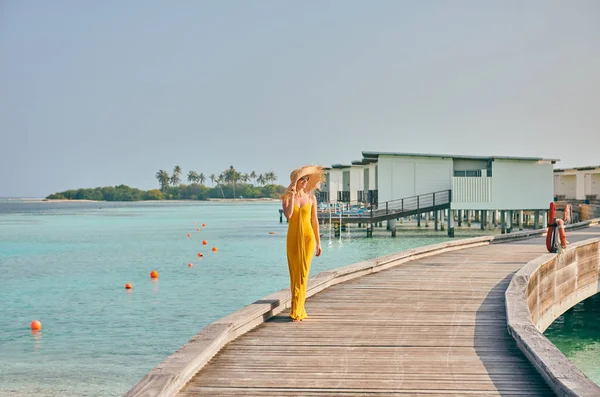 Жінка в одязі, що йде по тропічній пляжній дошці — стокове фото