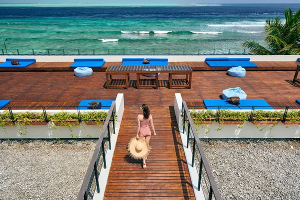 Femme en maillot de bain rayé sur patio de plage — Photo