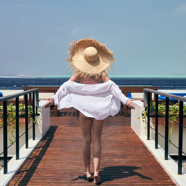 Женщина в полосатом купальнике в патио на пляже — стоковое фото