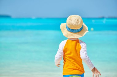 Plajda üç yaşında bir yürümeye başlayan çocuk