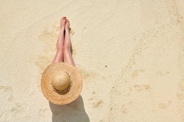 Plaj manzarası yukarıdan üzerinde oturan kadın