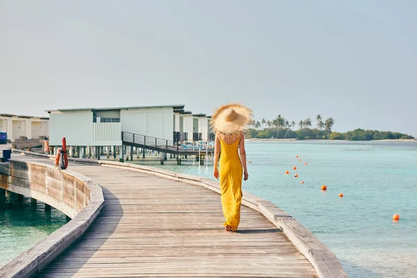 Γυναίκα με φόρεμα περπάτημα στην τροπική παραλία boardwalk — Φωτογραφία Αρχείου