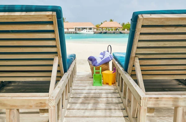 Tropisch strand met ligstoelen en palmbomen — Stockfoto