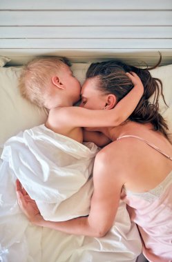 Üç yaşındaki küçük çocuk annesi ile yastık üzerinde uyku 