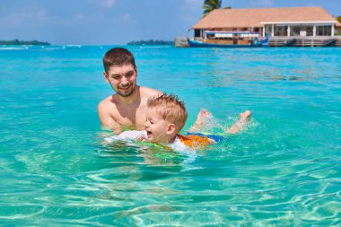 Üç yıl yaşlı yürümeye başlayan çocuk babası ile yüzmeyi öğrenir. Maldivler aile tatil yaz.