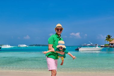 Babasıyla plajda üç yaşında küçük bir çocuk. Maldivler 'de yaz tatili.