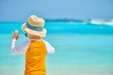 Plajda üç yaşında bir yürümeye başlayan çocuk