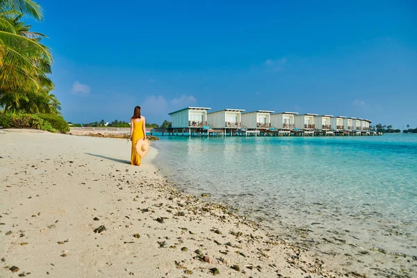 Kvinna i klänning gå på tropical beach — Stockfoto