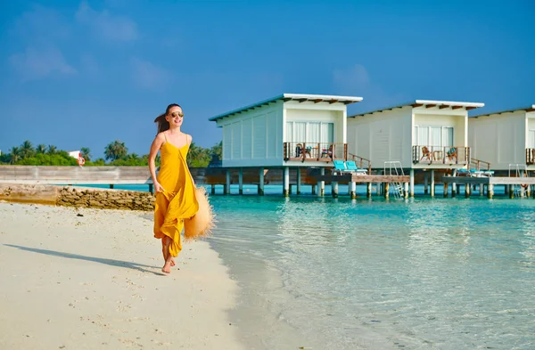 Donna in abito in esecuzione sulla spiaggia tropicale — Foto Stock