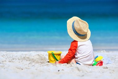 İki yaşında bir çocuk sahilde oynuyor.