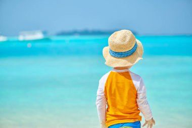 Plajda üç yaşında bir yürümeye başlayan çocuk