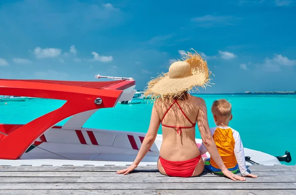 Toddler boy with mother sitting on wooden jetty — Stock Photo, Image