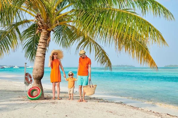 Família de três na praia sob palmeira — Fotografia de Stock