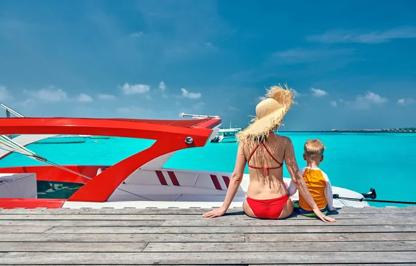 Toddler boy with mother sitting on wooden jetty — Stock Photo, Image