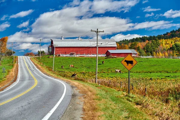 Carretera y granero rojo en el soleado día de otoño — Foto de Stock
