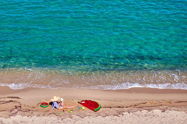 Jongen en zijn moeder op het strand met opblaasbare float — Stockfoto