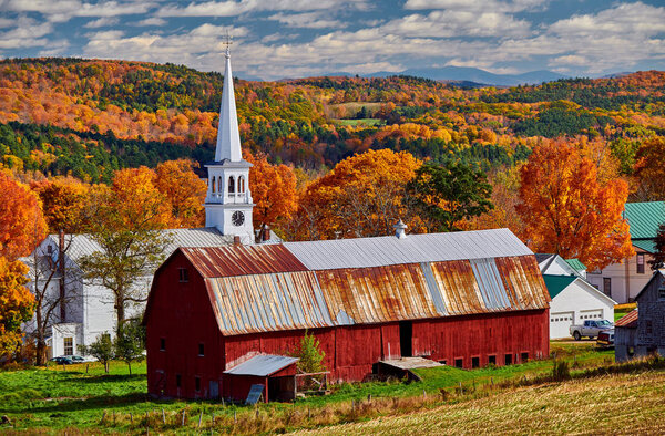 Church and farm with red barn at autumn