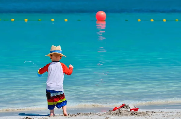 Två år gammal småbarn leker på stranden — Stockfoto