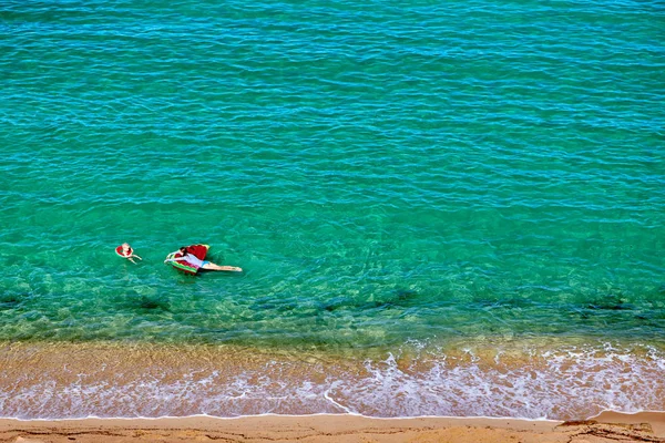 Jongen en zijn moeder op het strand met opblaasbare float — Stockfoto
