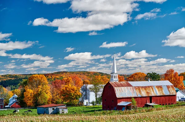 Церковь и ферма с красным амбаром осенью — стоковое фото