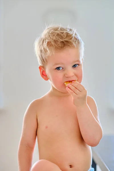 Due anni vecchio ragazzo mangiare arancia — Foto Stock