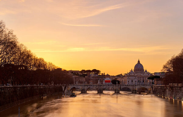 St. Peter's cathedral and Tiber river at sunset in Rome