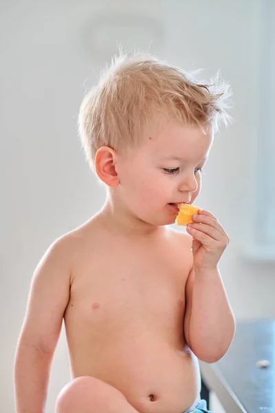 Dwa lata stary chłopak jedzenie pomarańczowy — Zdjęcie stockowe