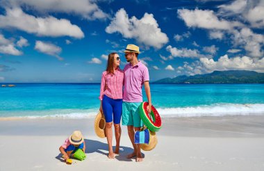 Güzel Anse Soleil plajında bir aile, üç yaşında bir çocuğu olan genç bir çift. Seyşeller 'de yaz tatili, Mahe..