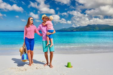 Güzel Anse Soleil plajında bir aile, üç yaşında bir çocuğu olan genç bir çift. Seyşeller 'de yaz tatili, Mahe..