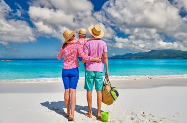 Güzel Anse Soleil plajında bir aile, üç yaşında bir çocuğu olan genç bir çift. Seyşeller 'de yaz tatili, Mahe..