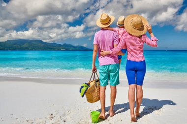 Güzel Anse Soleil plajında bir aile, üç yaşında bir çocuğu olan genç bir çift. Seyşeller 'de yaz tatili, Mahe..