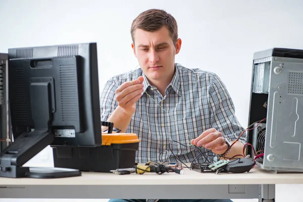 Young technician repairing computer in workshop — Stock Photo, Image