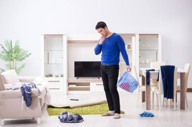 Genç adam çamaşırhane için kirli çamaşır topluyor.