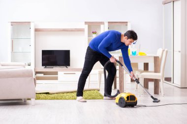 Genç adam evini temizliyor.