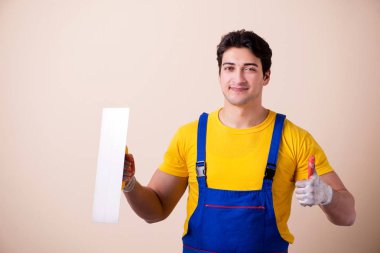 Duvara alçı yapıştıran genç müteahhit.