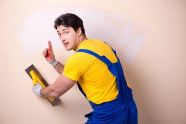 Duvara alçı yapıştıran genç müteahhit.