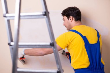 Duvara alçı yapıştıran genç müteahhit.